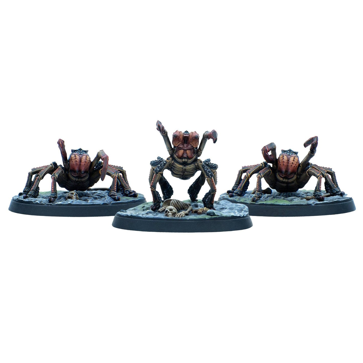 Three brown and red spider-like miniatures on bases, the central one rears up over a small skeleton