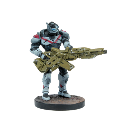 A miniature of a futuristic armored soldier in black and gray armor with red accents, holding a large olive-drab rifle