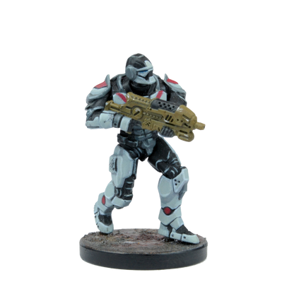 Sci-fi miniature of an armored soldier in black, white, and red armor, holding a gold assault rifle