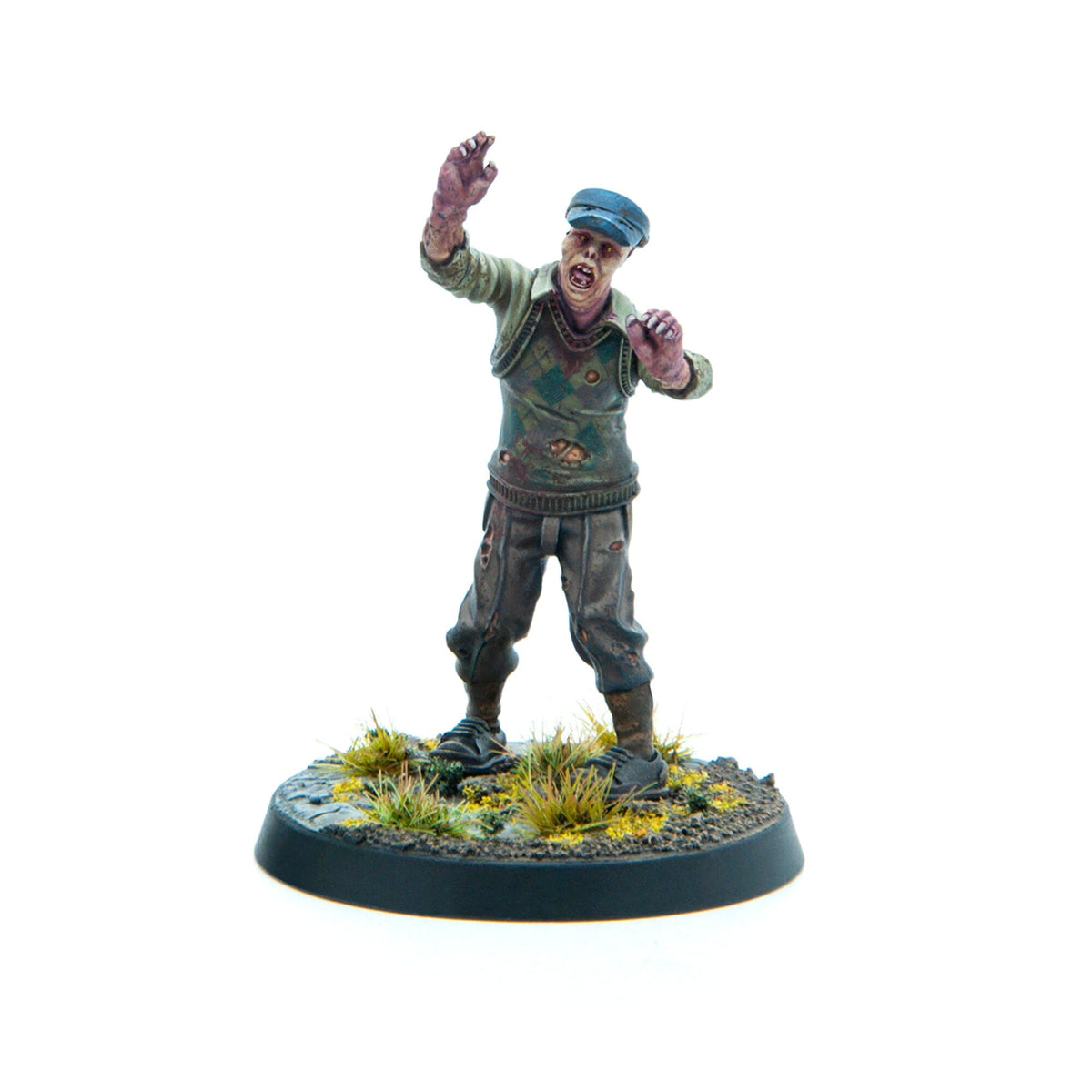 A miniature zombie in a blue cap, torn green sweater, and ripped pants, lurching with outstretched arms on a grassy base