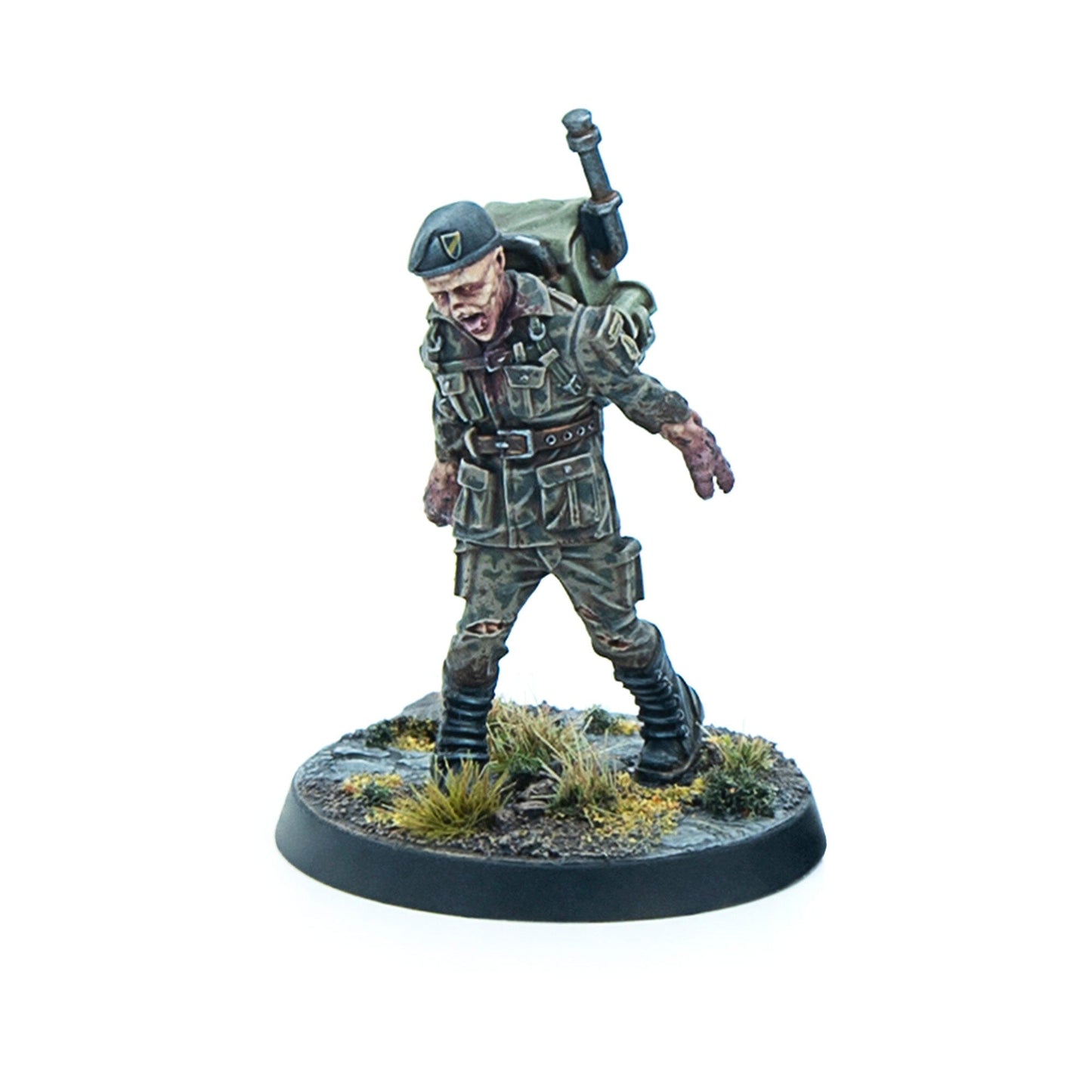 Miniature of a zombie soldier wearing a green beret and tattered camo, with an open mouth, shambling forward on a terrain base