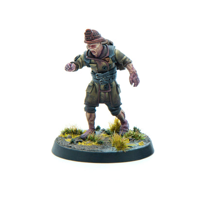 A miniature of a zombified miner in an olive uniform and hard hat, lunging forward with an open mouth