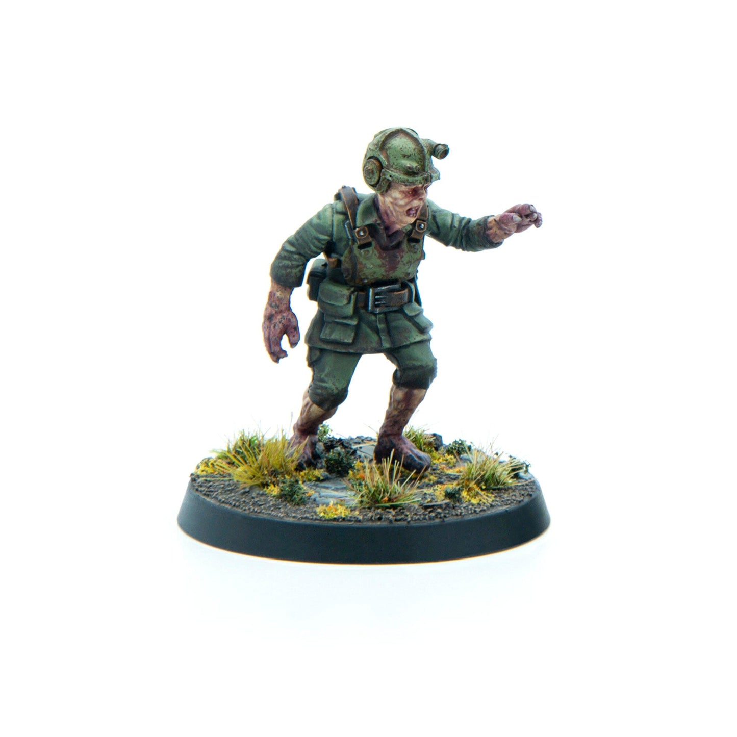 Zombie soldier miniature in green uniform and helmet, stumbling forward with an outstretched arm on a round base
