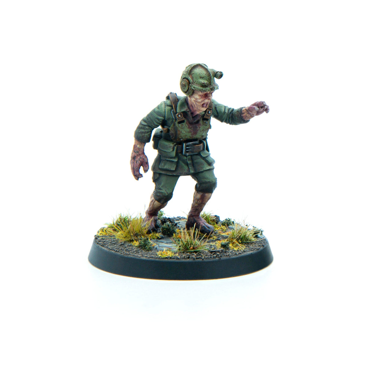 Zombie soldier miniature in green uniform and helmet, stumbling forward with an outstretched arm on a round base