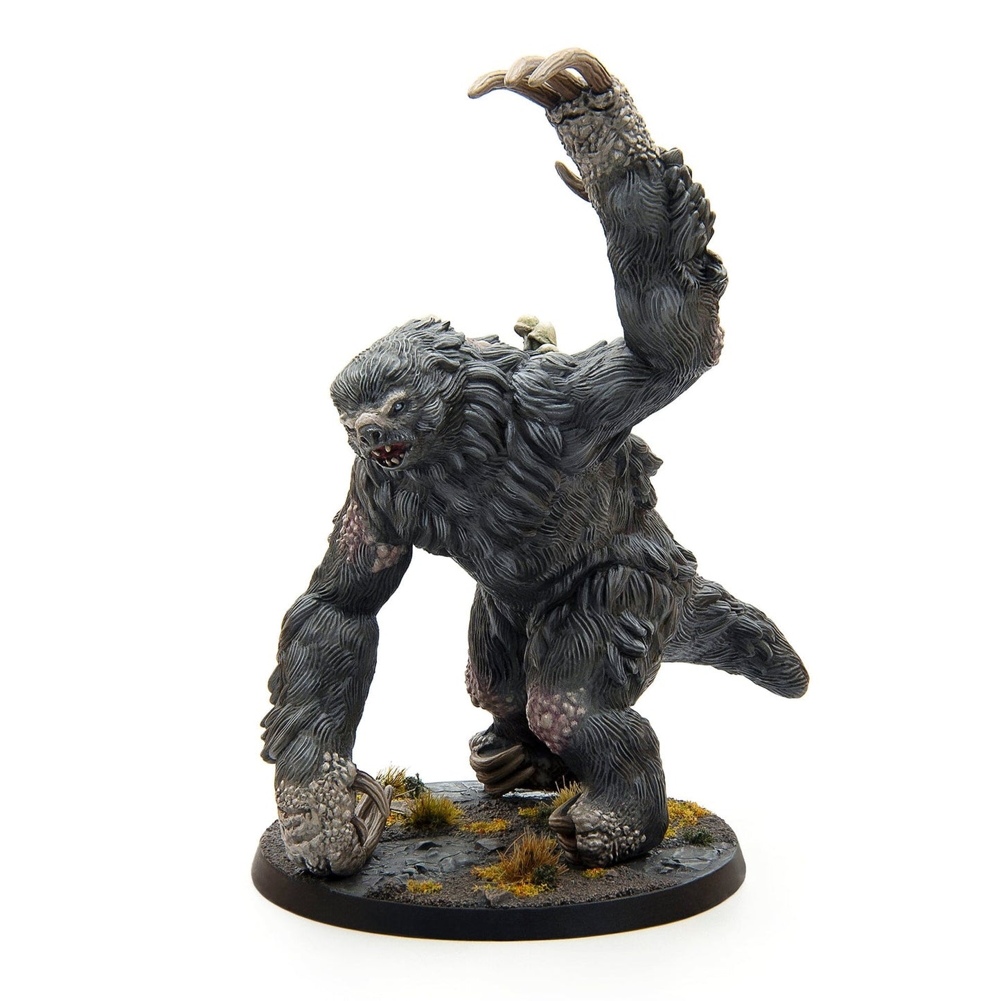 Dark, furred monster miniature raising its massive, clawed arm aggressively on a terrain base