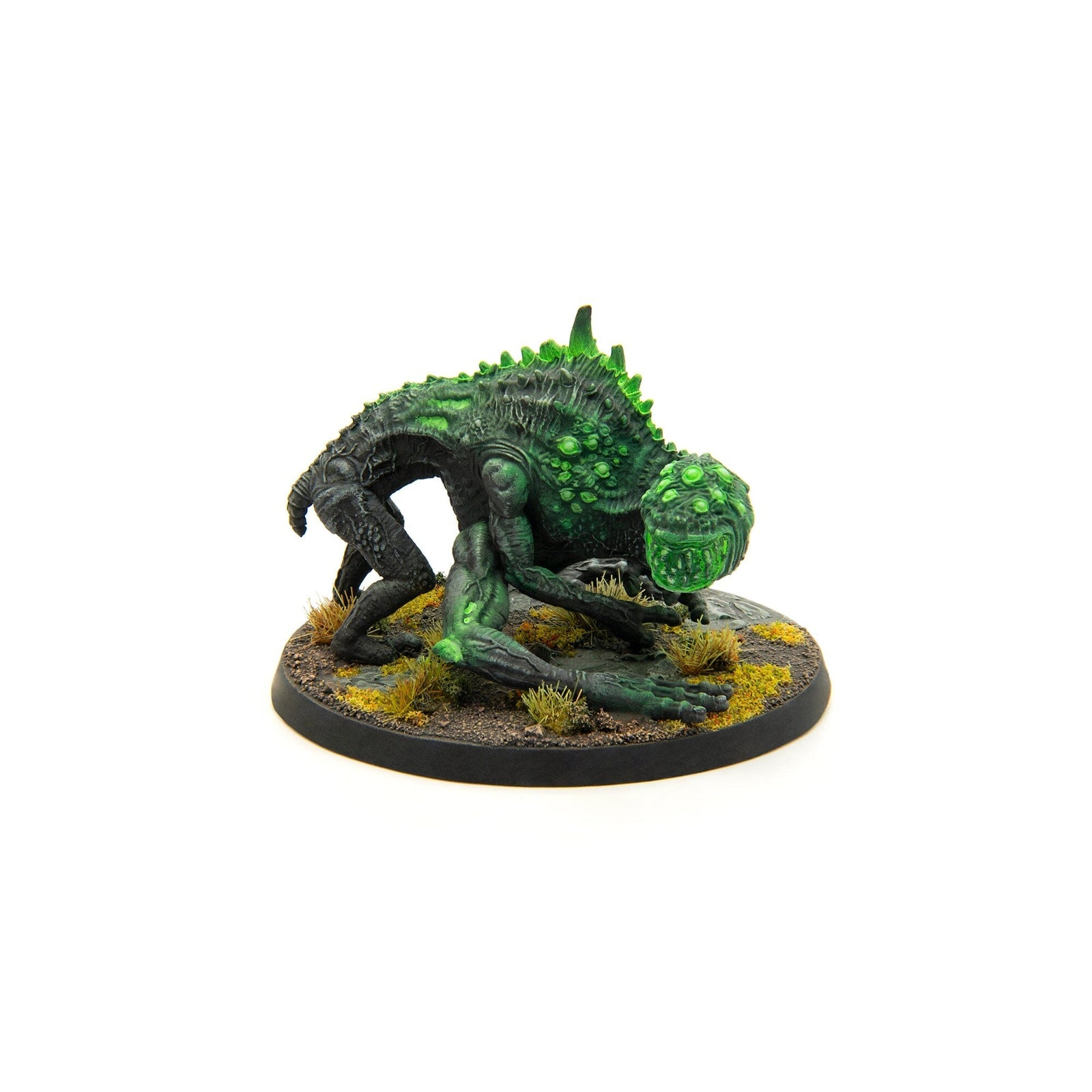Hand-painted miniature of a dark green, multi-eyed alien creature crouching low on a scenic base