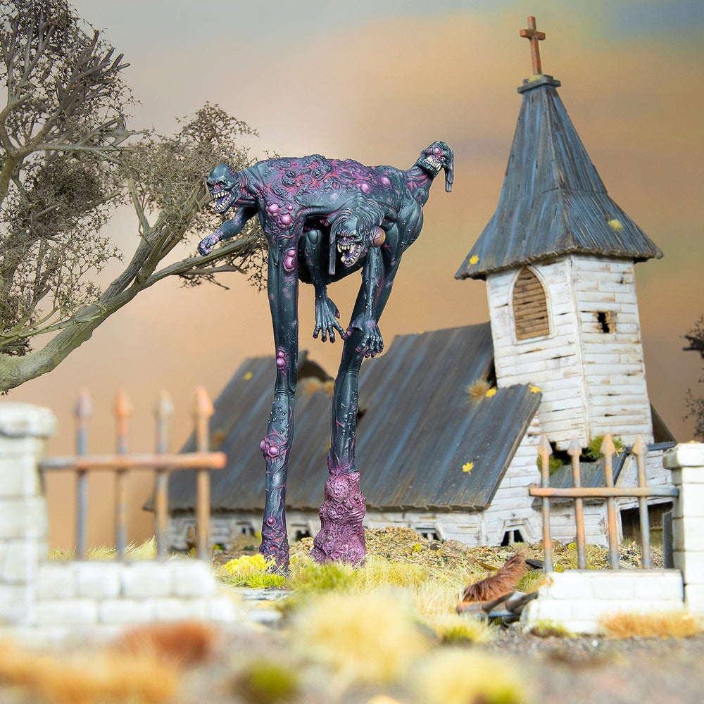 Miniature: Grotesque, multi-headed monster with long legs towers over a dilapidated church and a bare tree.