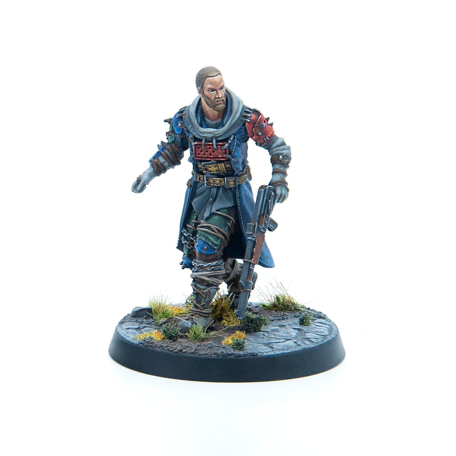 A painted miniature of a bearded man in rugged blue clothing, holding a rifle and advancing on a textured base.