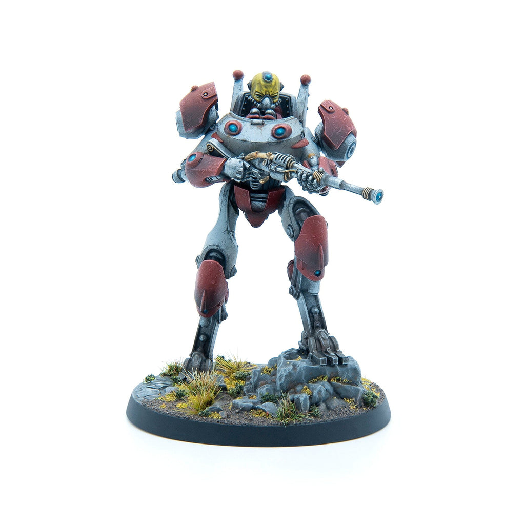 A grey and red armored sci-fi mech miniature holds a long rifle on a textured base.