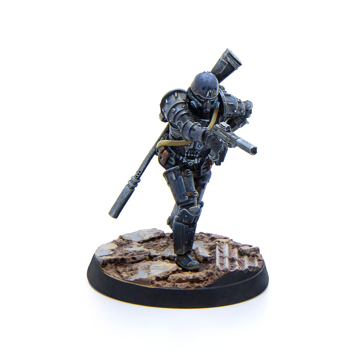 A miniature figure of a soldier in dark gray armored suit and helmet holding a rifle, standing on a textured base