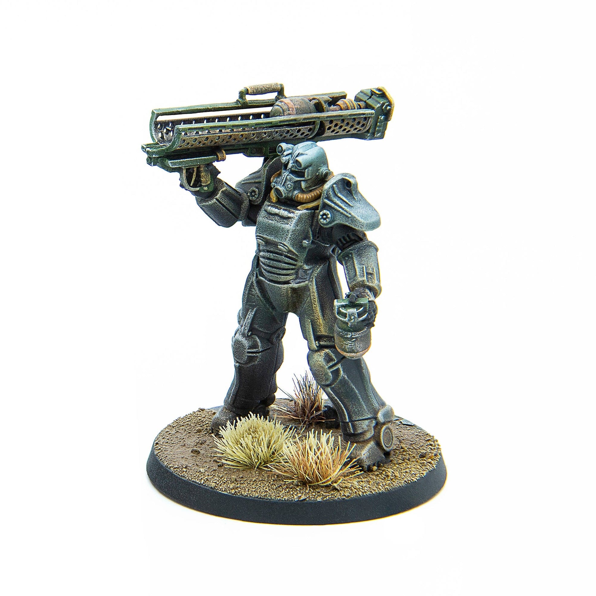 A Fallout Wasteland Warfare miniature depicts a Brotherhood of Steel figure in power armor holding a large rifle on a textured dirt base with dried grass