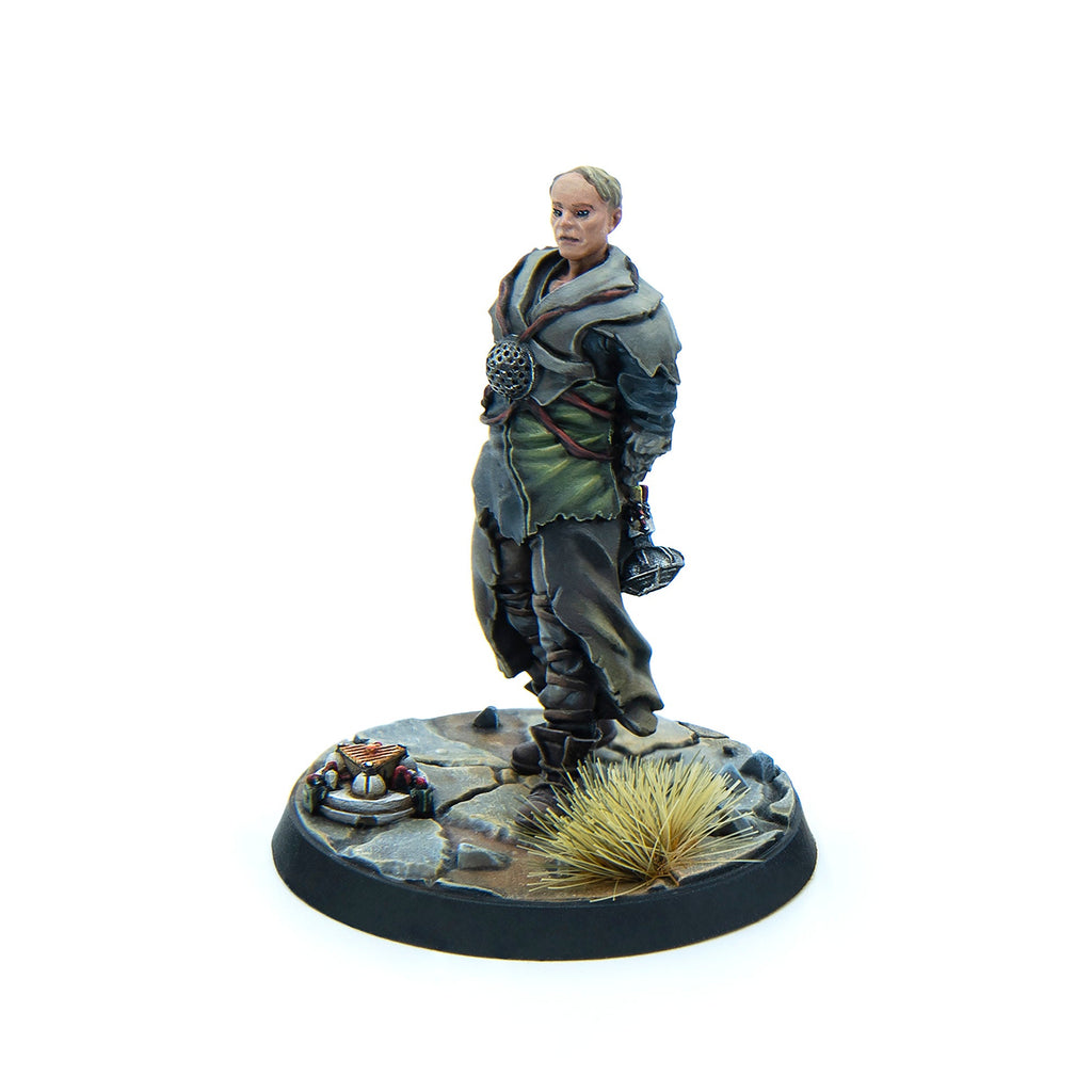 A painted miniature of a woman with short hair in worn, layered clothing, holding a mace. She stands on a rocky base with a small altar