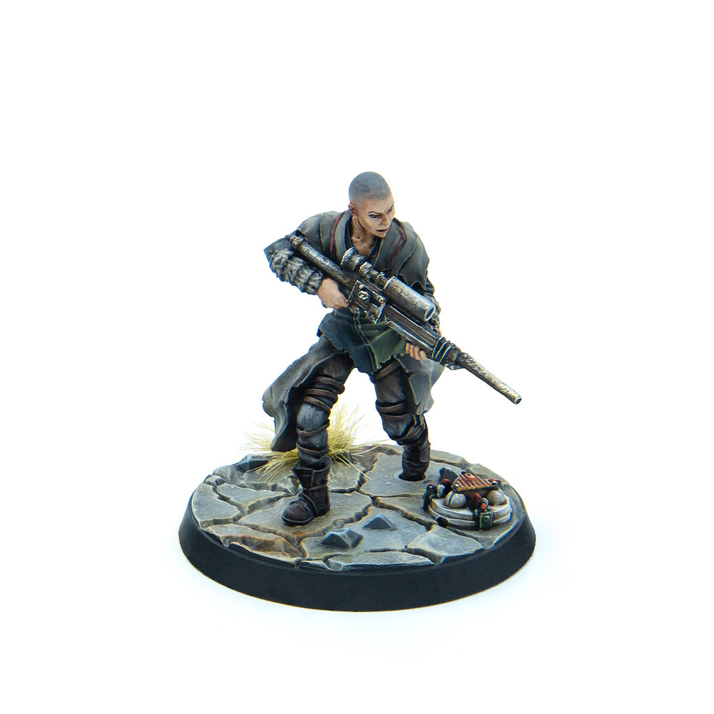 Painted miniature of a bald woman in a long coat, holding a large sniper rifle in a ready stance on a cracked base