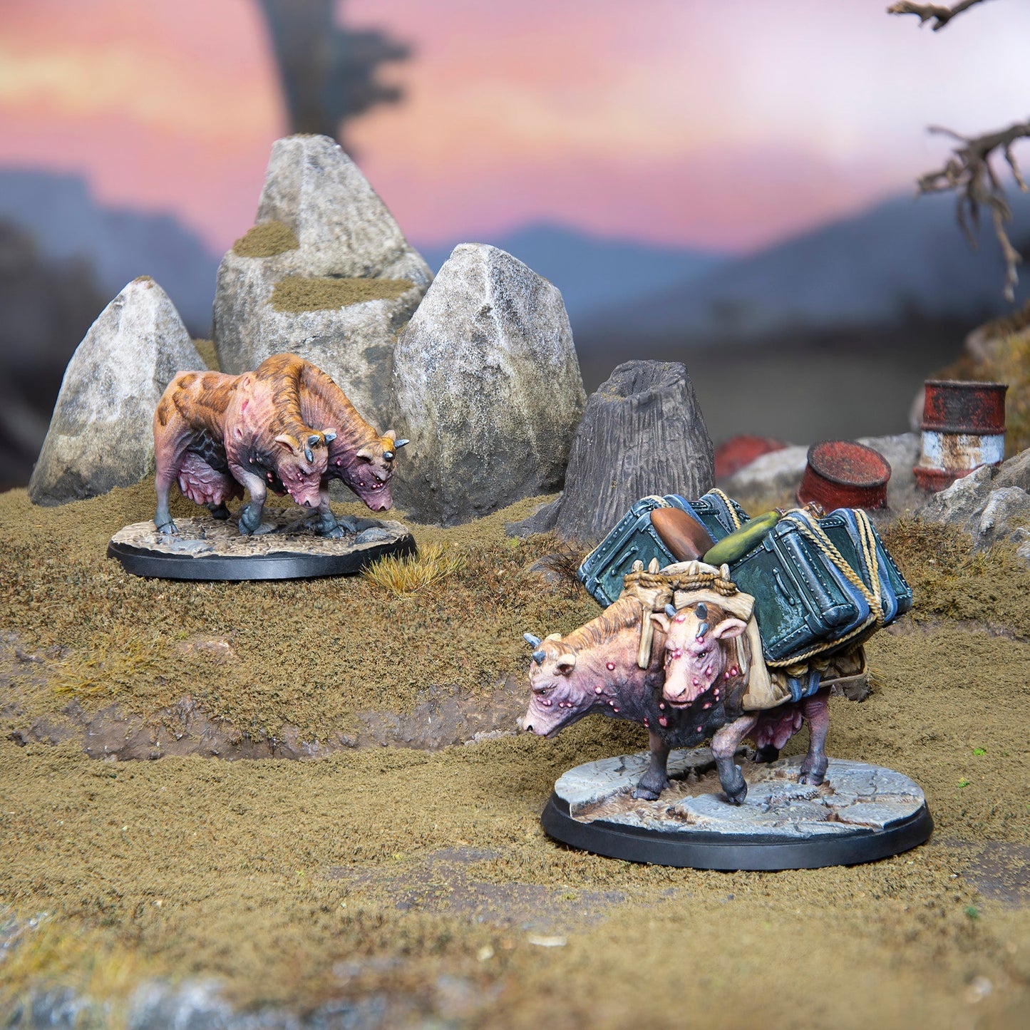 The Fallout Wasteland Warfare Creatures Brahmin Herd models feature two two-headed cows on a rocky, grassy terrain, one carrying green luggage, against a sunset sky