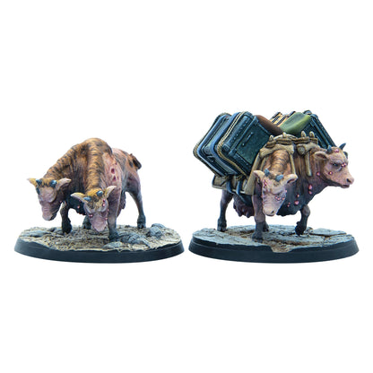 Two Fallout Wasteland Warfare miniatures of two-headed, mutated brown cows, one a pack animal with bags and the other plain, both with pink lesions