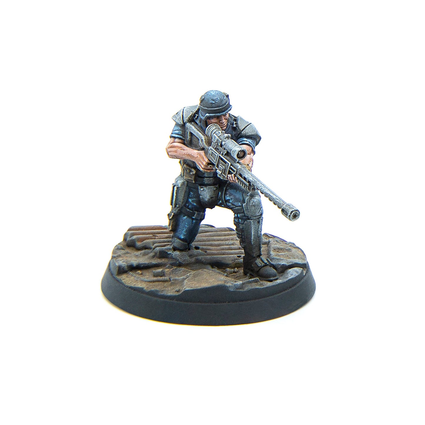 A painted miniature of a futuristic soldier in armor, crouching and aiming a large sniper rifle on a textured base