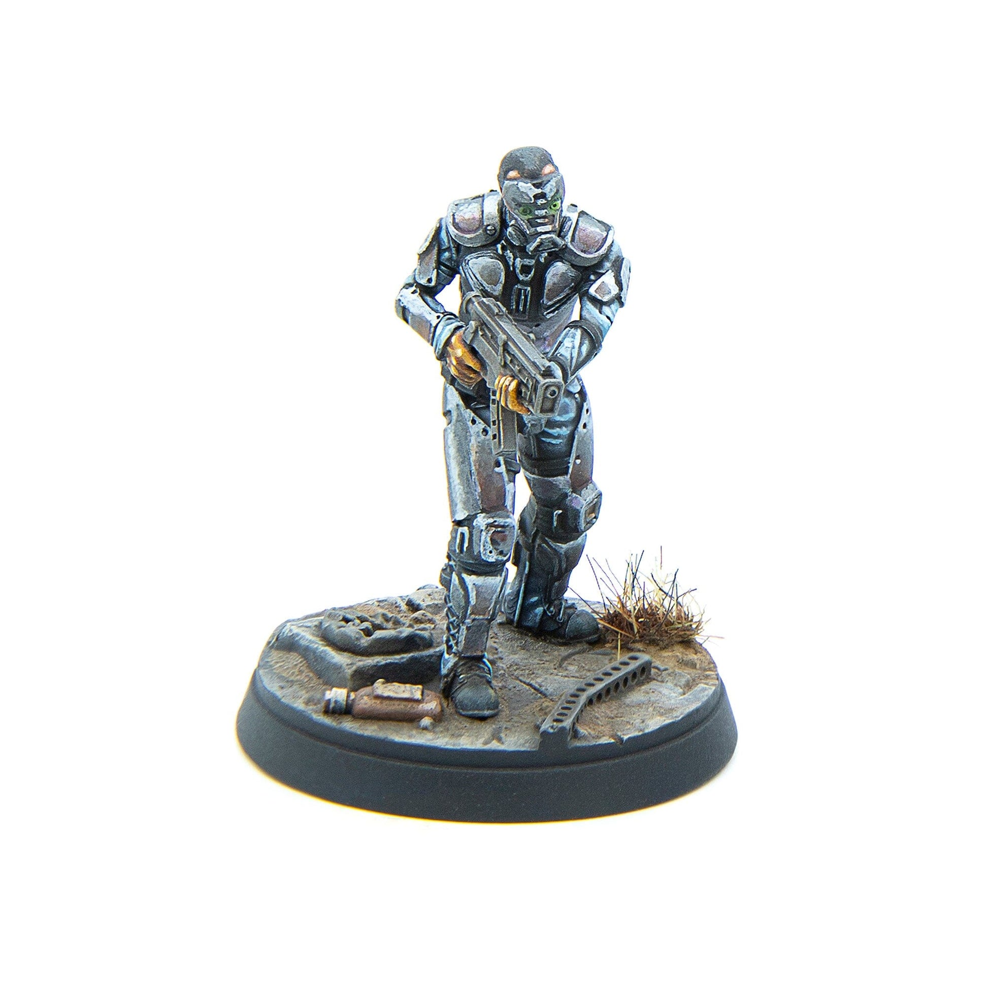 A miniature armored sci-fi trooper with a green glowing visor, holding a rifle, on a debris-strewn base
