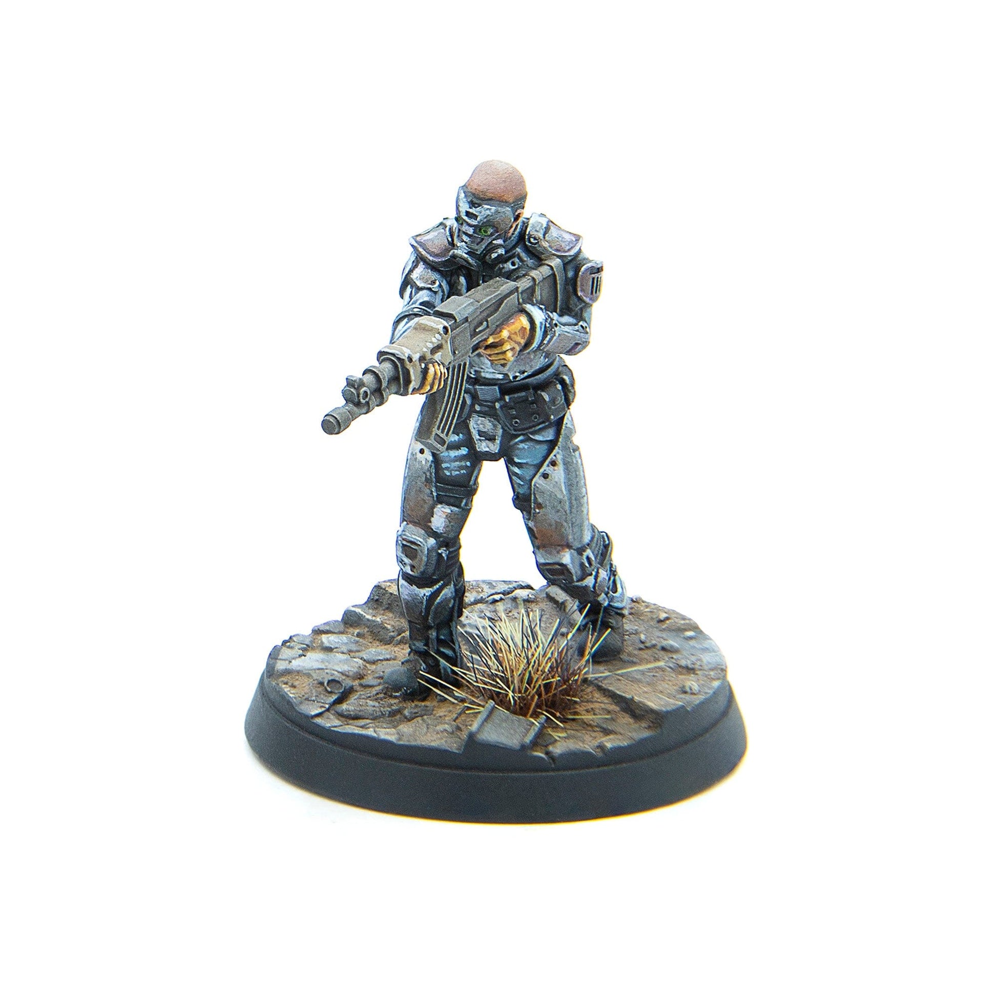 A painted miniature of a futuristic soldier in grey battle armor, holding a rifle, standing on a rocky, debris-strewn base