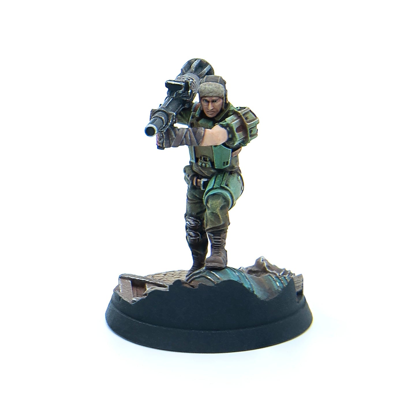 A painted miniature soldier in green uniform, fur hat, holding a heavy weapon over his shoulder, on a rubble base