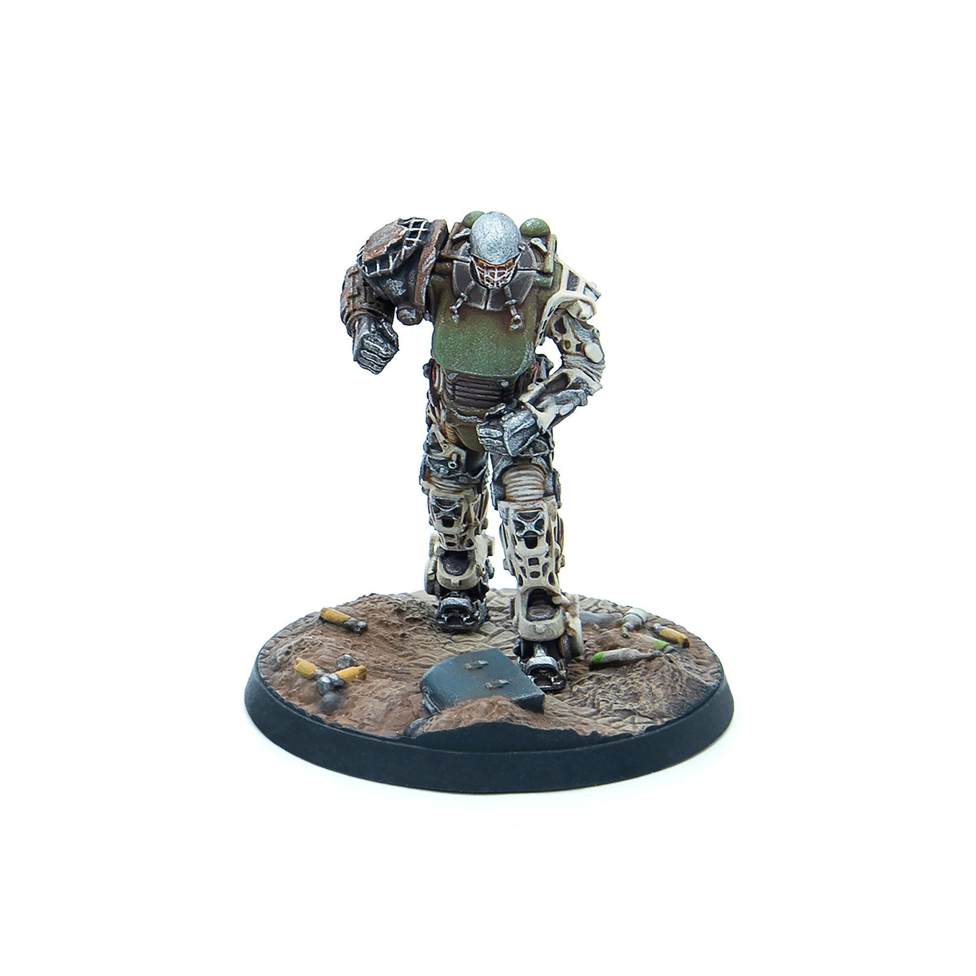 A miniature armored figure in green and brown armor with a helmet and face cage, stepping forward on a debris-strewn wasteland base