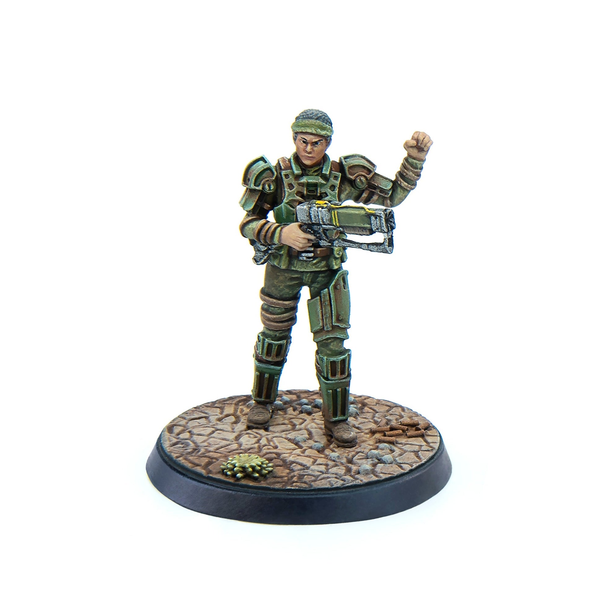 Green armored sci-fi miniature figure holding a rifle, with their left fist raised
