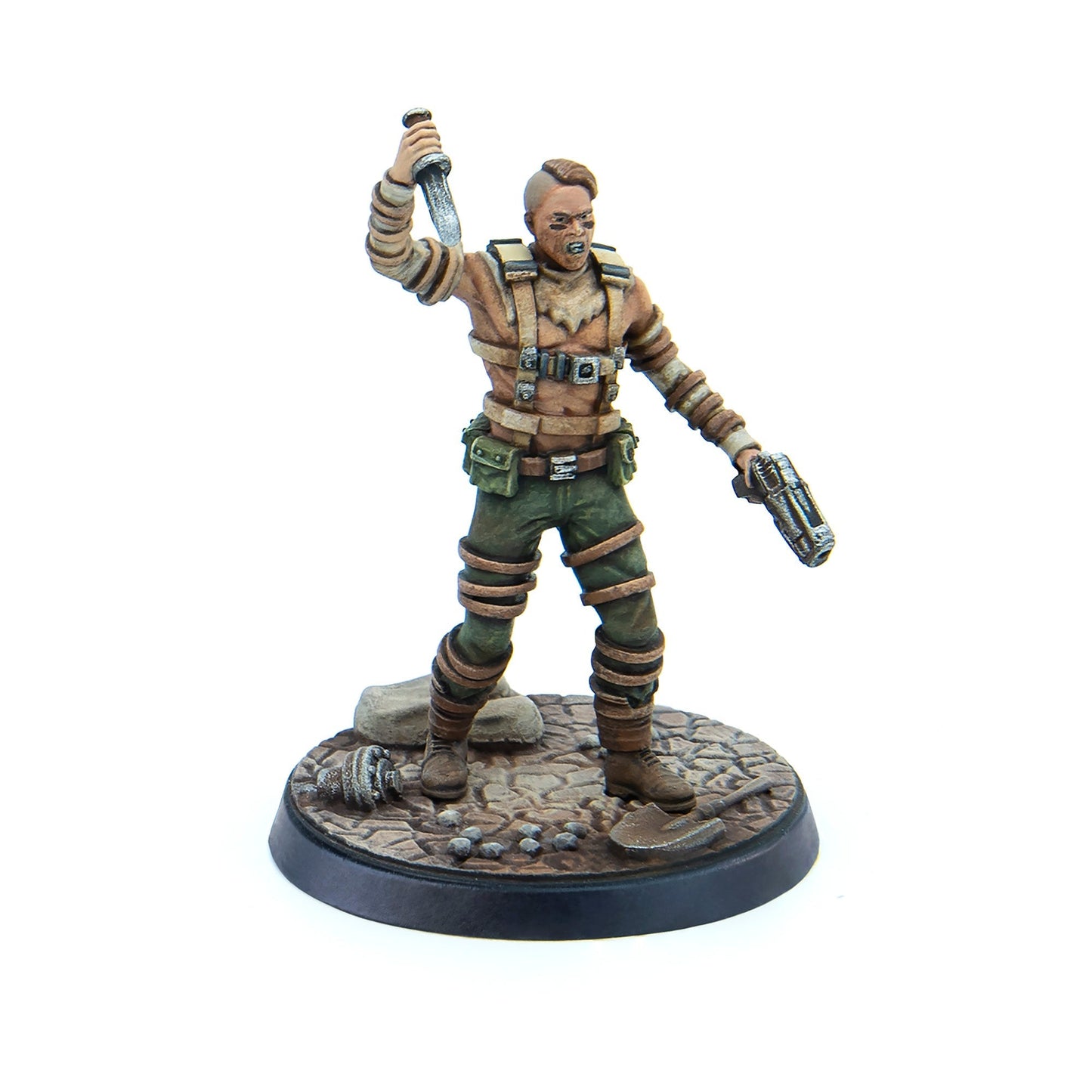 A snarling post-apocalyptic miniature figure holds a raised knife and a pistol, standing on a rocky base with debris