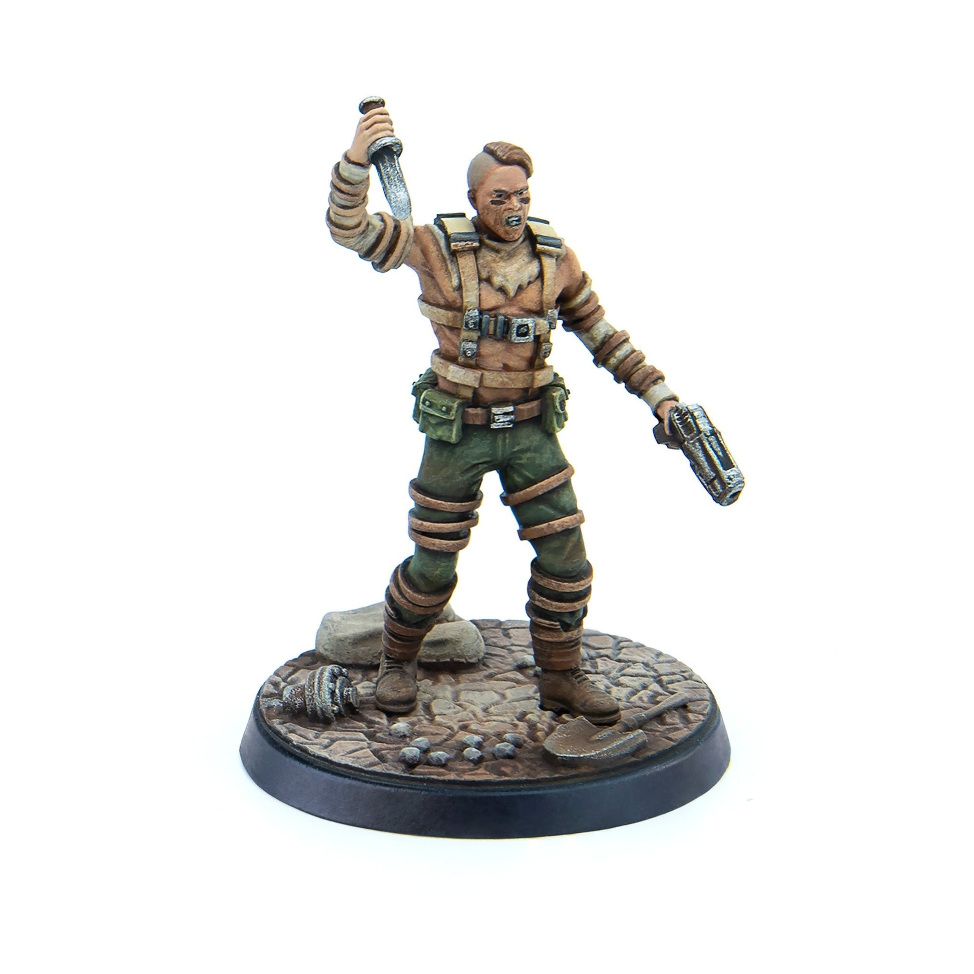 A snarling post-apocalyptic miniature figure holds a raised knife and a pistol, standing on a rocky base with debris