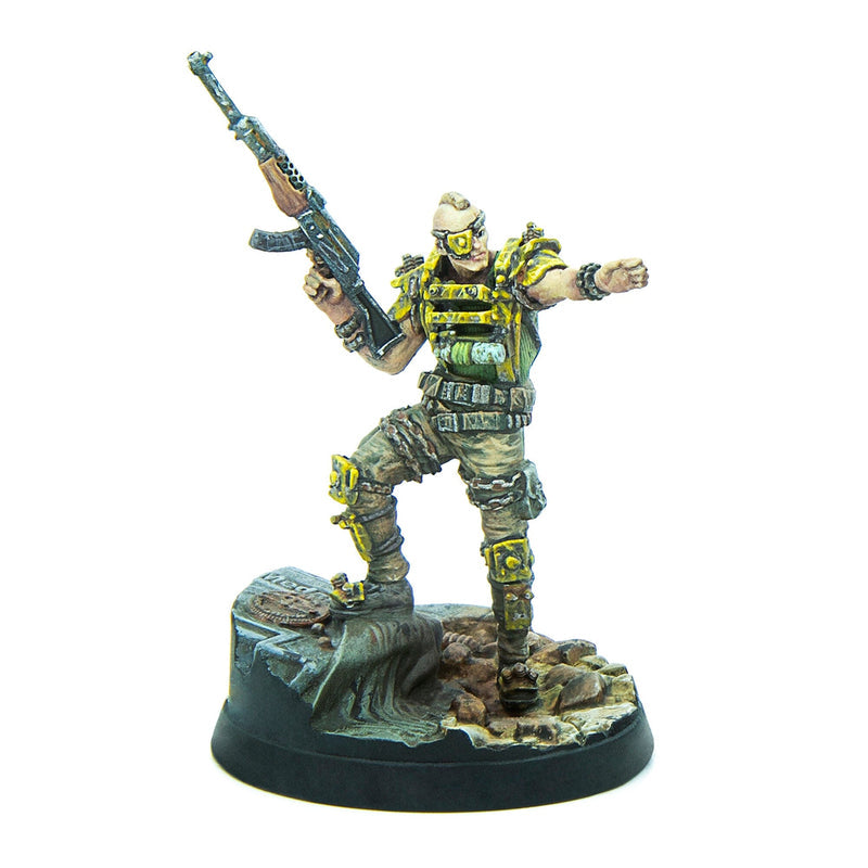 Miniature post-apocalyptic warrior with mohawk, yellow armor, holding a rifle, arm outstretched