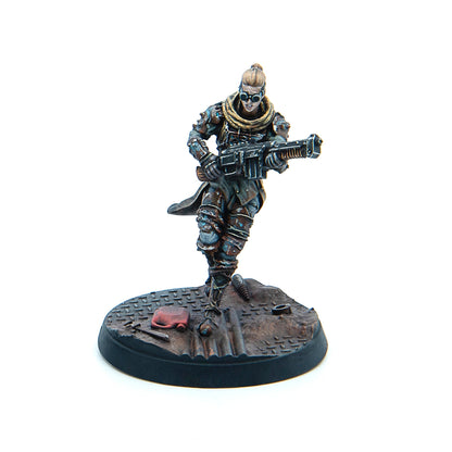 Painted miniature: female character with a top bun and goggles, armored, running with a heavy rifle
