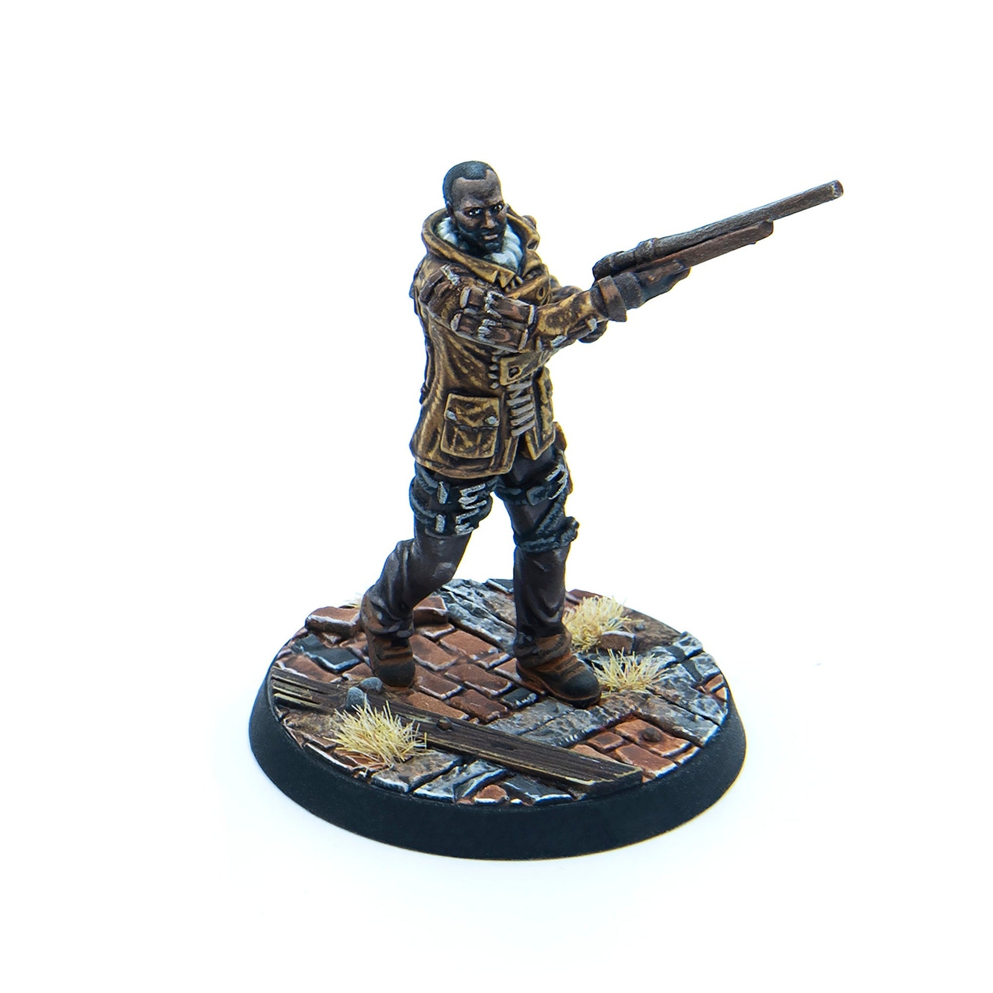 Painted miniature of a dark-skinned man in a brown jacket, aiming a long gun while standing on a ruined cobblestone base