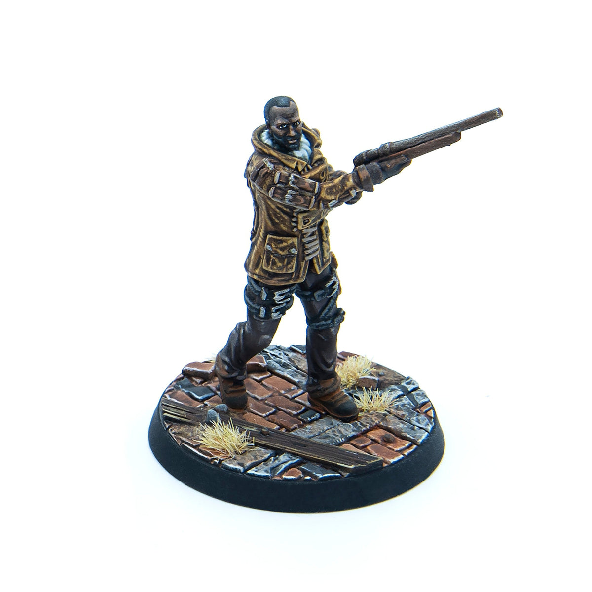 Painted miniature of a dark-skinned man in a brown jacket, aiming a long gun while standing on a ruined cobblestone base