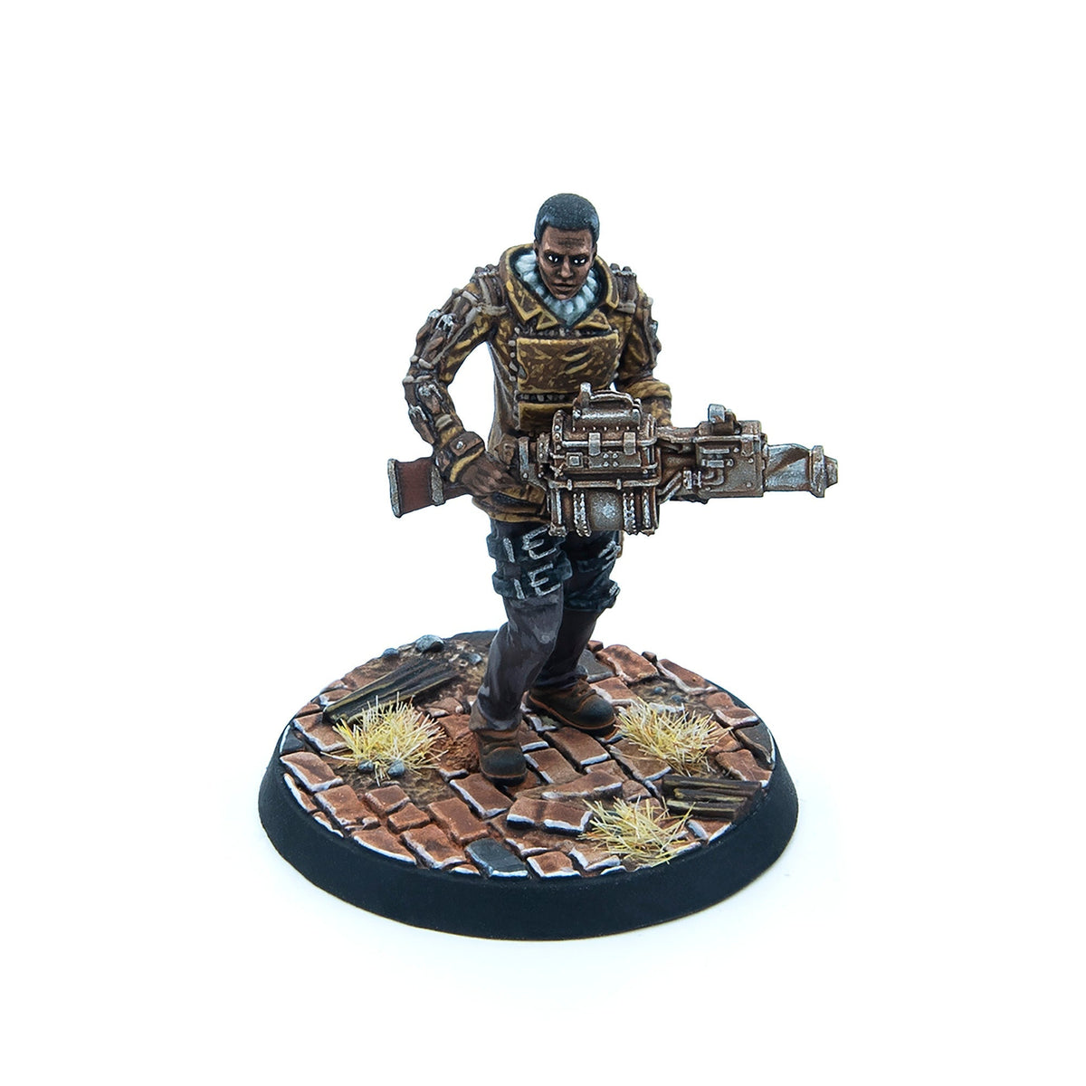 A painted miniature of a dark-skinned man in a brown jacket, holding a heavy futuristic gun, on a cobblestone base