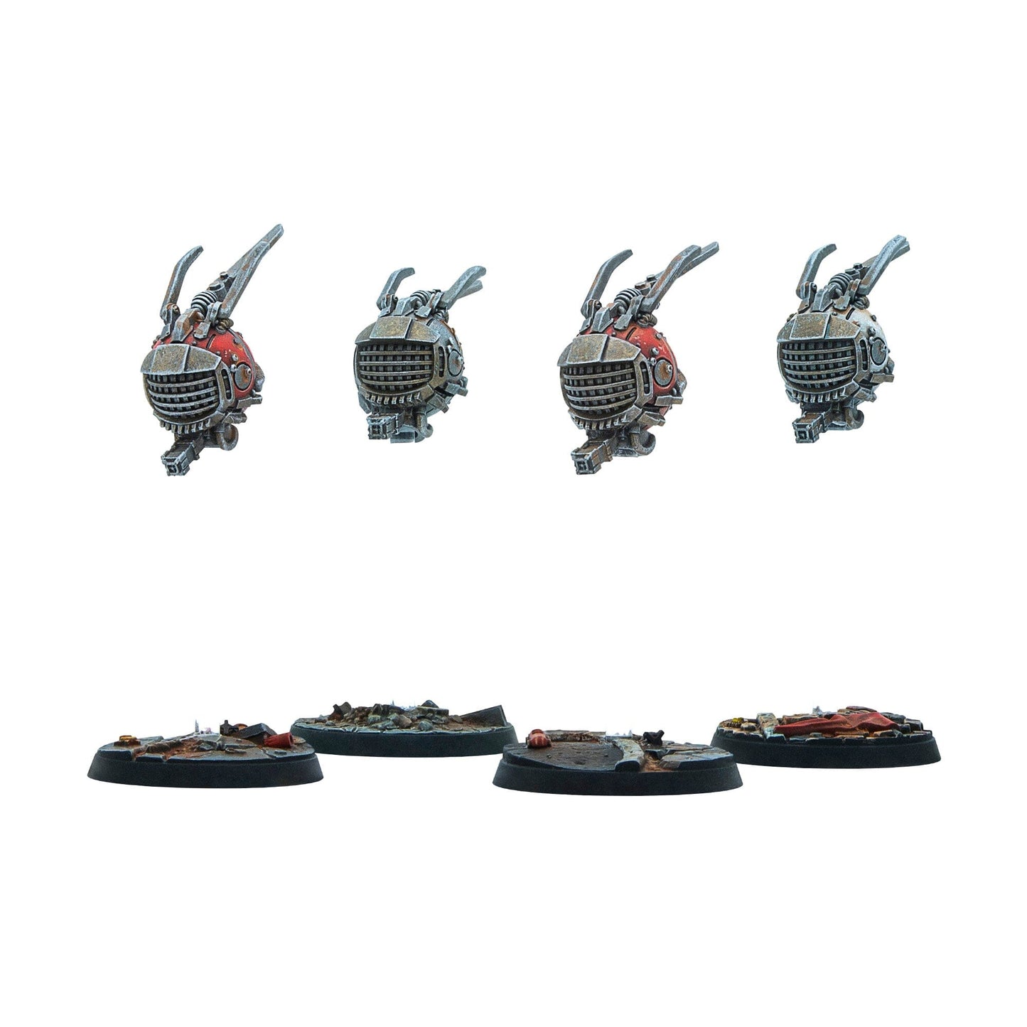 Four miniature robot components (two red, two grey) with claw arms, displayed above four rubble-covered bases