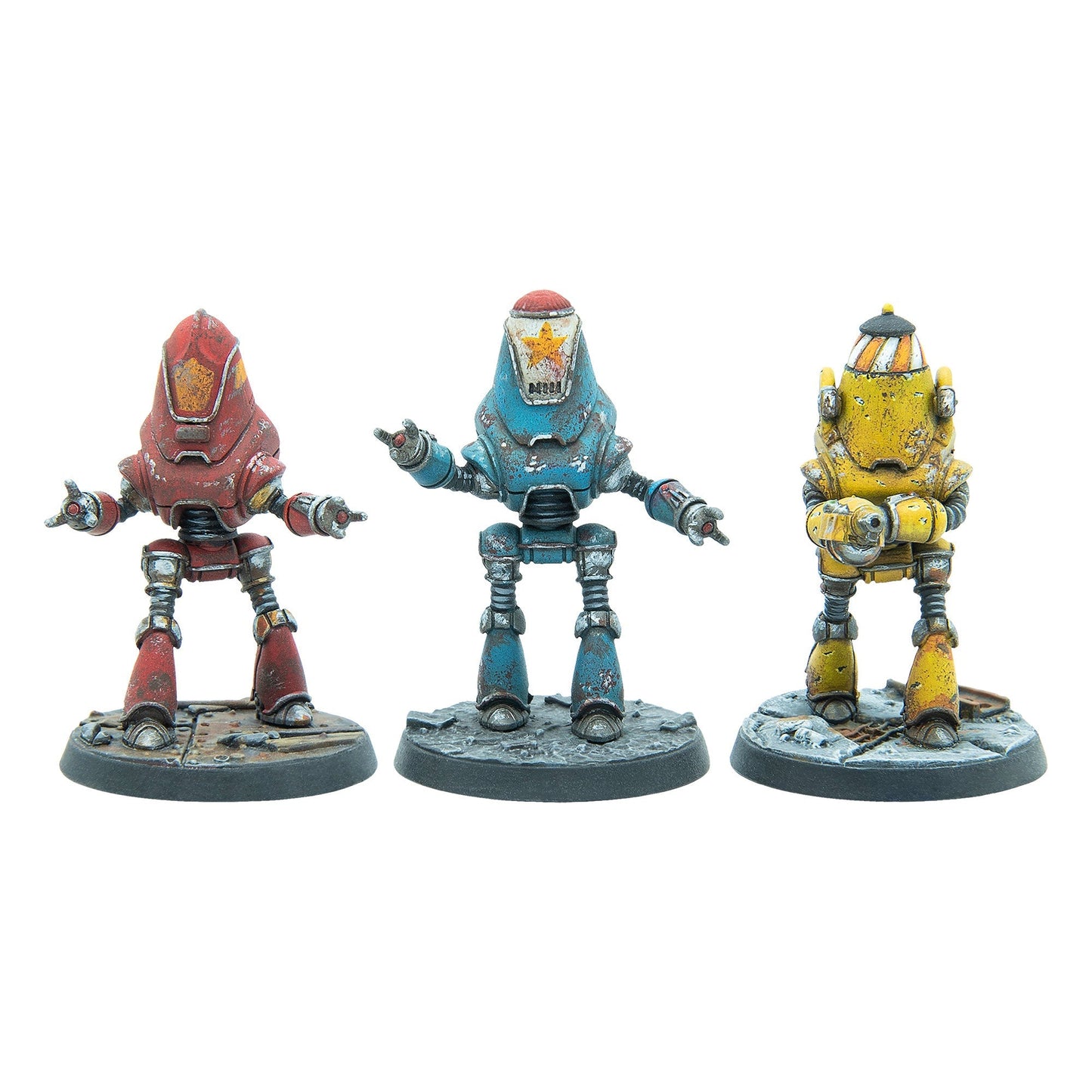 Three weathered robot miniatures: a red one, a blue one with a star, and a yellow one holding a weapon