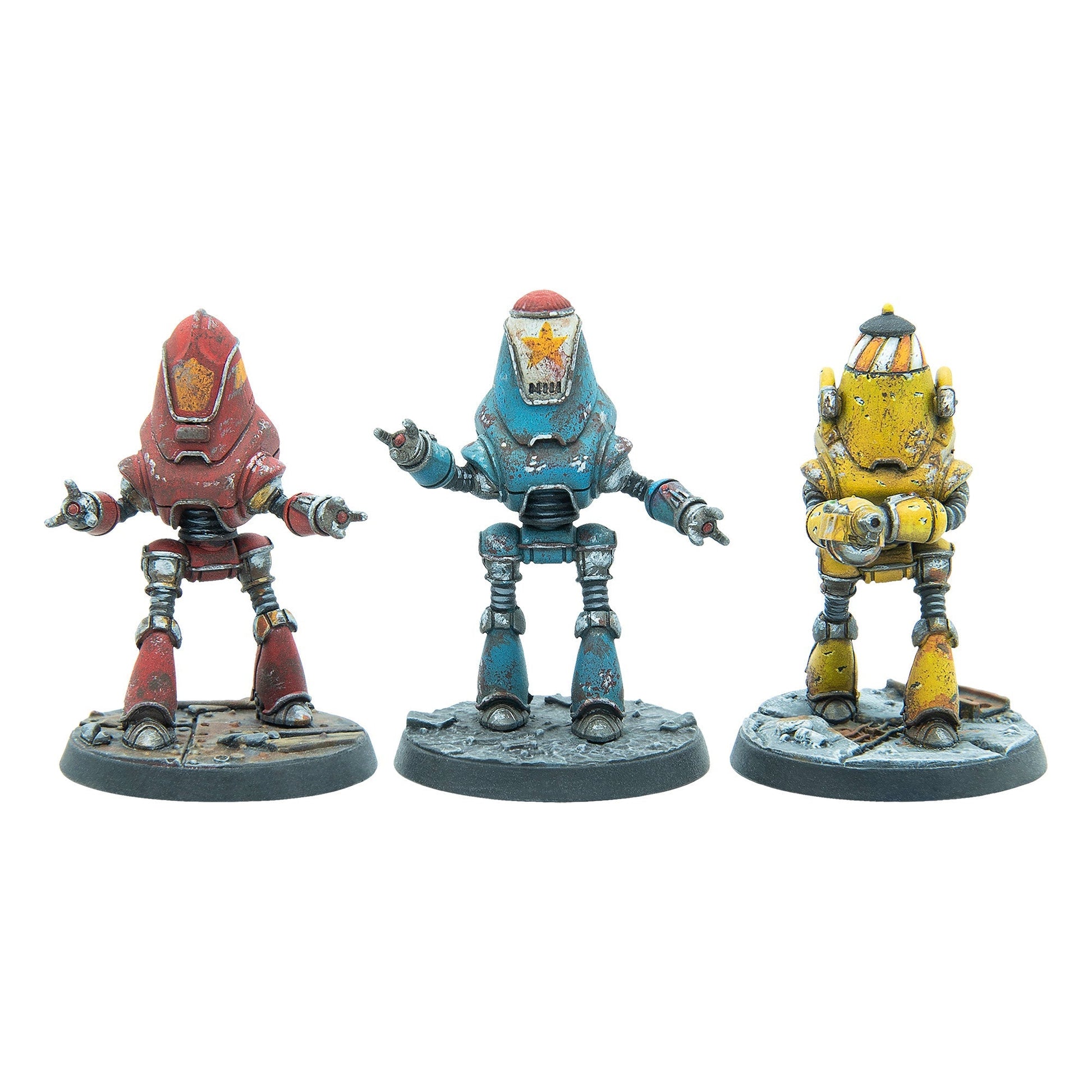 Three weathered robot miniatures: a red one, a blue one with a star, and a yellow one holding a weapon