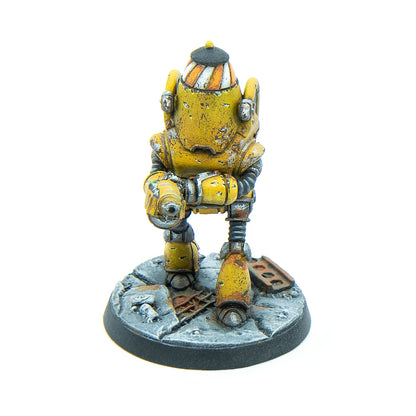 A rusty yellow robot miniature with a striped conical hat, standing on a rubble base and holding a blaster