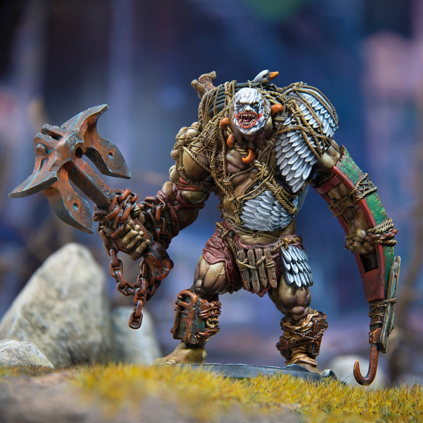 A detailed miniature of a hulking, armored fantasy brute with a grimacing face, holding a chained anchor-axe and a shield-hook