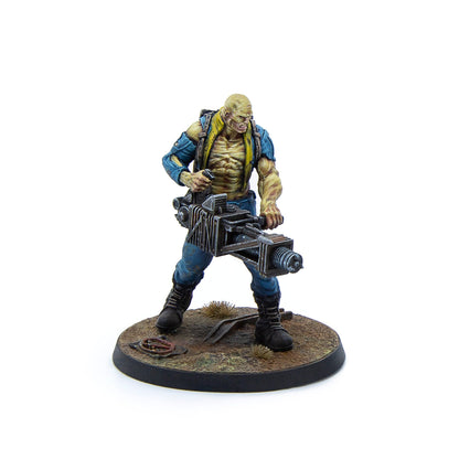 A snarling, yellow-skinned mutant miniature in blue clothes, gripping a heavy industrial weapon