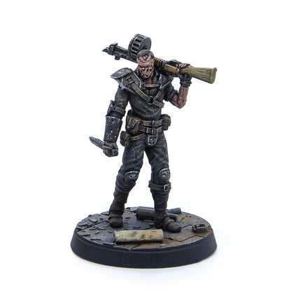 Painted miniature of a ghoulish figure with exposed skull, shouldering a rocket launcher and holding a knife