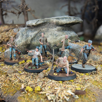 Six post-apocalyptic miniature figures, some with ghoul-like faces, are shown scavenging in a rocky wasteland