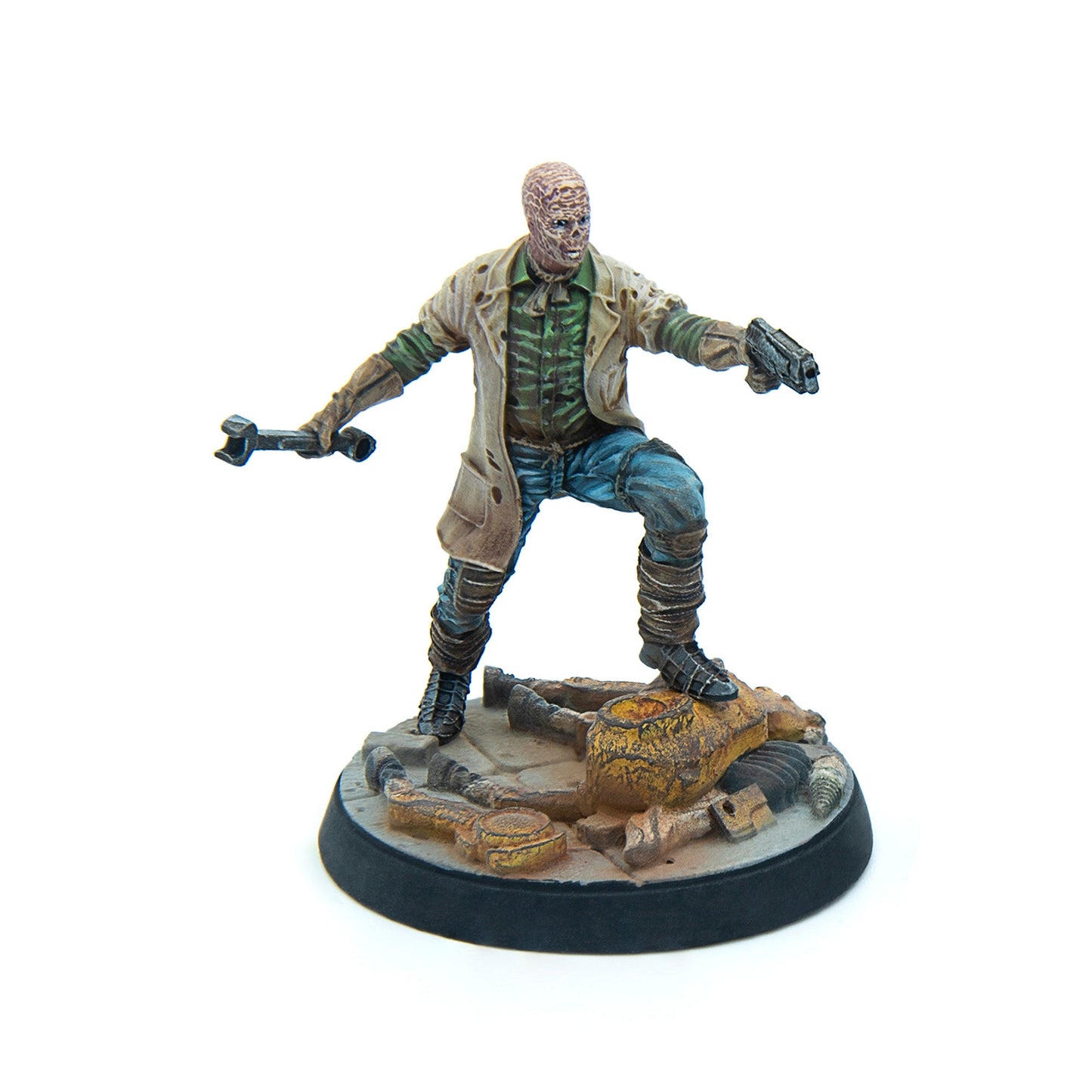 A painted miniature of a ghoul-like character in a trench coat, holding a pistol and wrench, standing on rusted debris