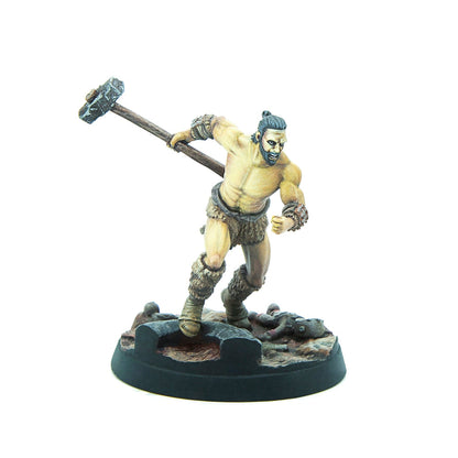 Painted miniature of a muscular, bare-chested fantasy warrior in fur, running forward with a large hammer raised