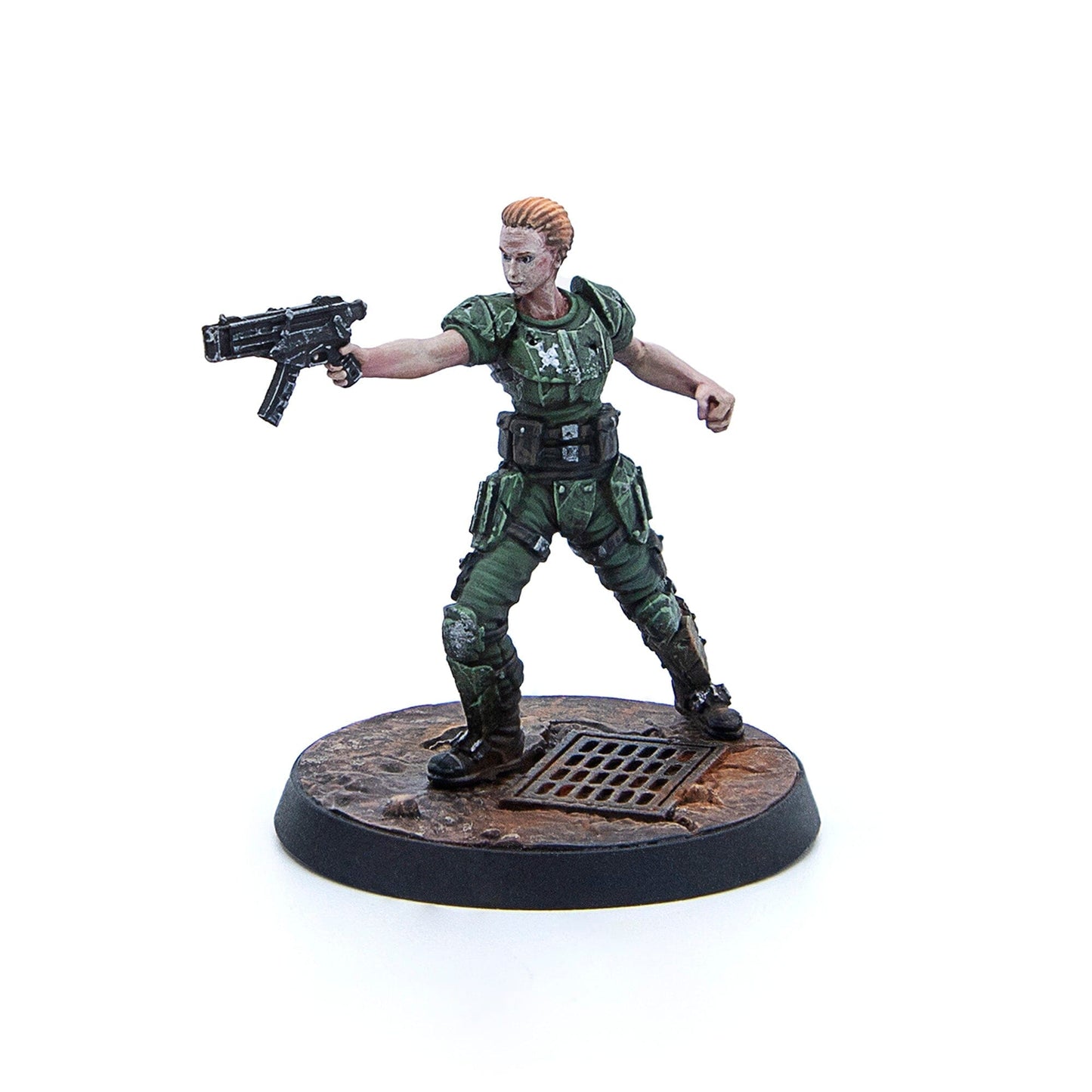 A miniature female soldier in green armor with short blonde hair aims a futuristic submachine gun on a dirty base with a grate