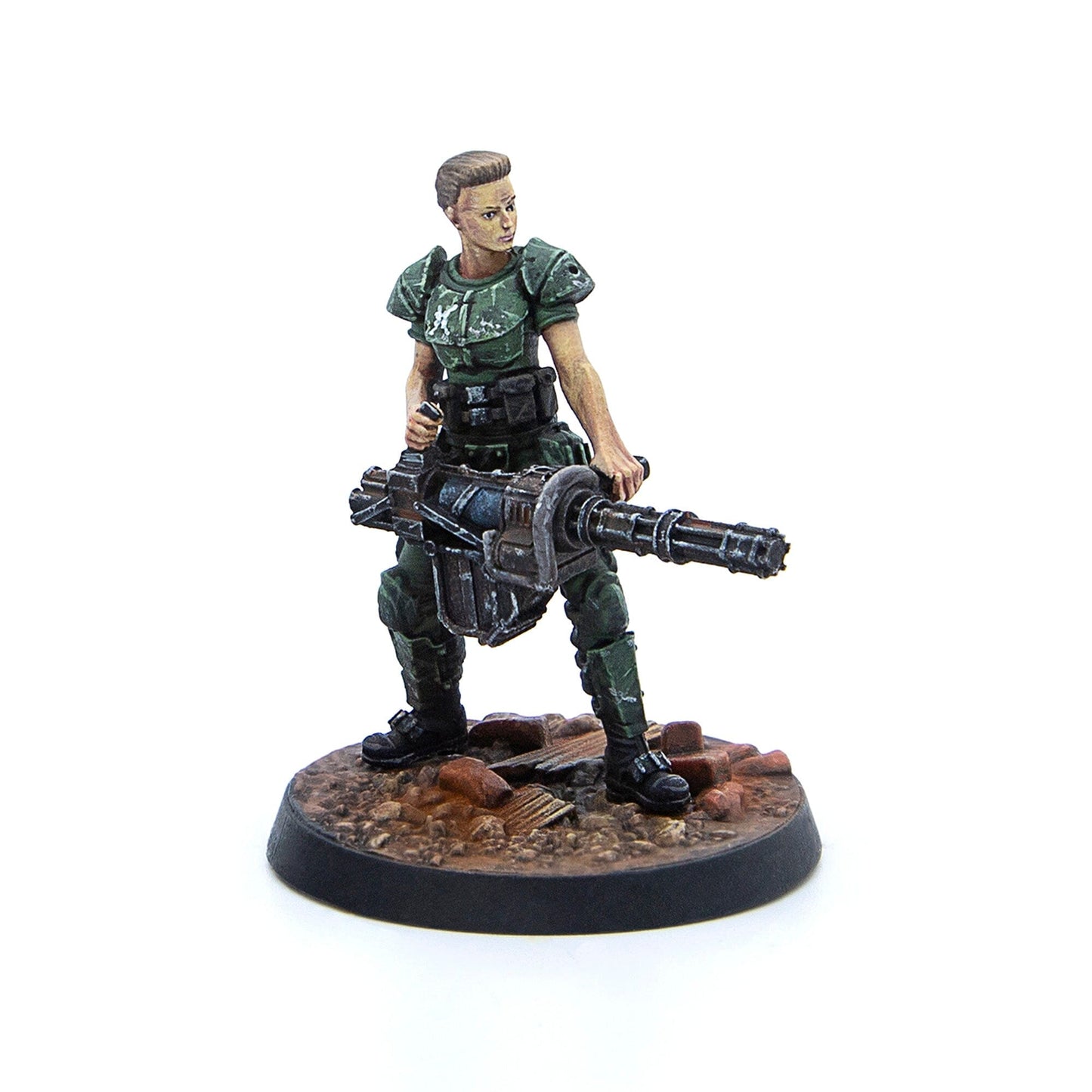 Painted female miniature in green armor holds a large minigun on a rubble base
