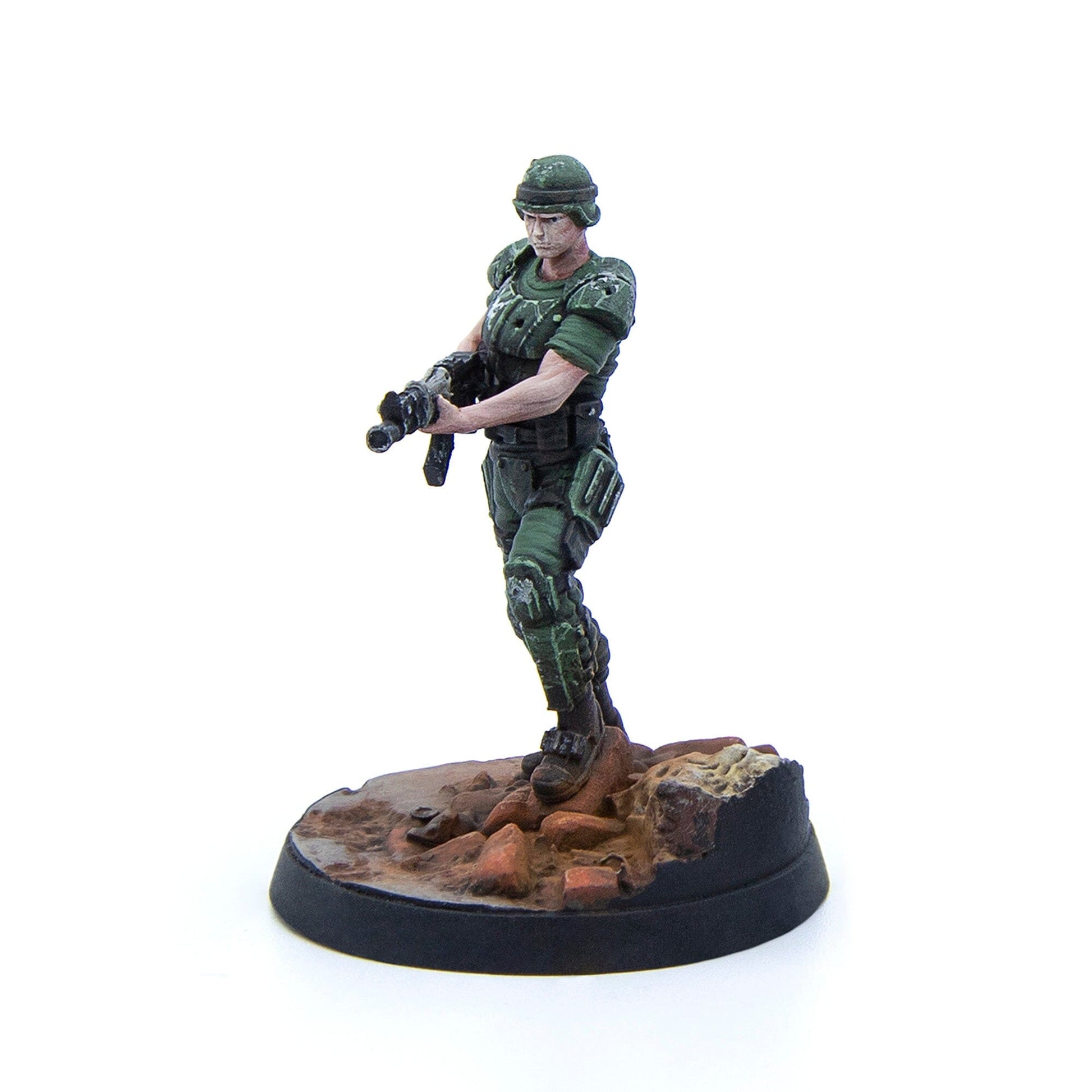 A miniature soldier in green armor and helmet stands holding a rifle on a rocky base