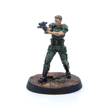 A painted miniature of a male soldier in green armored uniform, aiming a sci-fi rifle, standing on a textured base