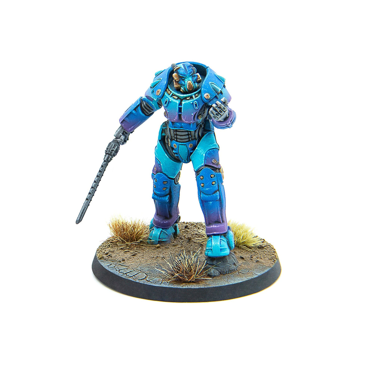 A miniature blue and purple armored sci-fi figure holds a spiked staff on a cracked earth base