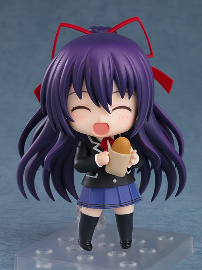 Chibi figure of a girl with long purple hair and red bows wearing a school uniform holding a snack in her hands