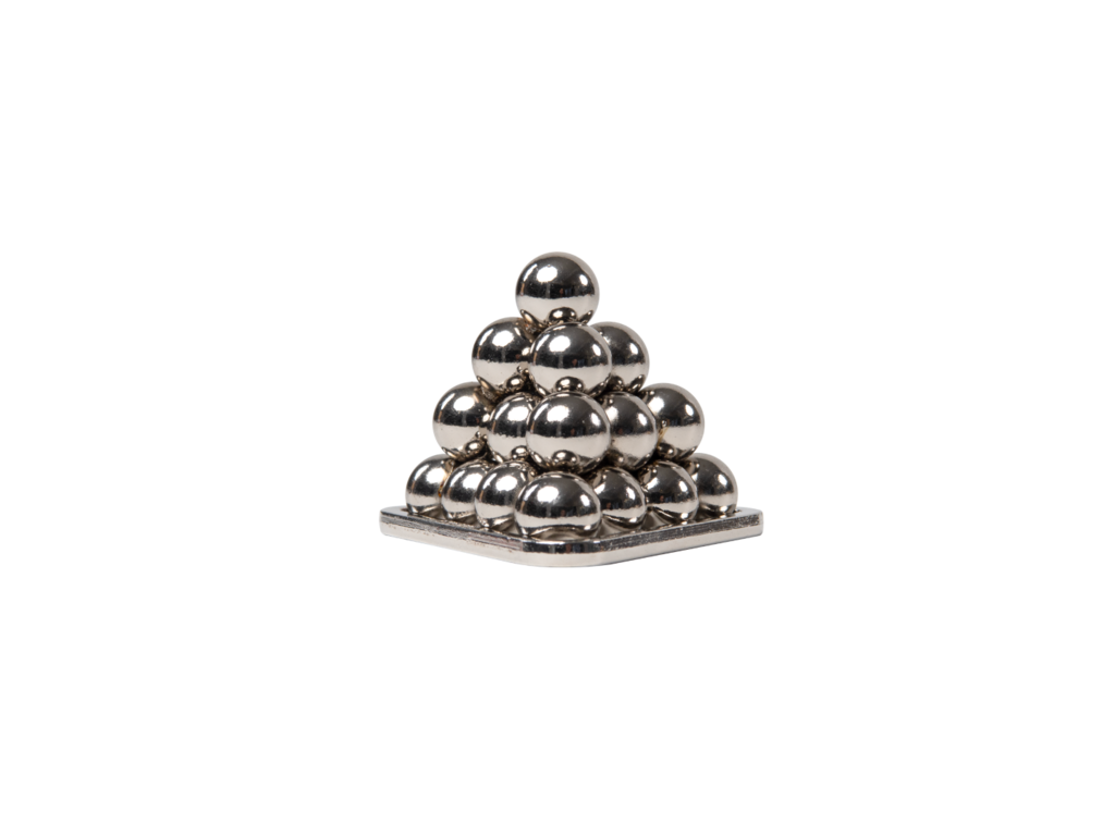 Shiny metallic spheres stacked in a small pyramid shape, resting on a flat square base against a black background