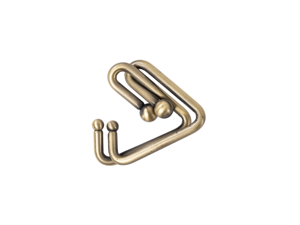 Stylized antique brass double hook accessory with ball tips, isolated on black